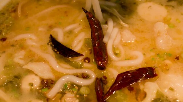Close Up of Spicy Rice Noodle Soup with Chili Peppers and Fish Balls