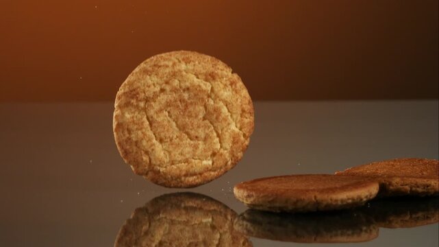 Assorted delicious cookies falling and gracefully stacking into a neat pile on a dark reflective surface studio shot