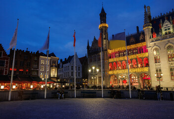 Obraz premium Night view of illuminated historic town hall square in Bruges