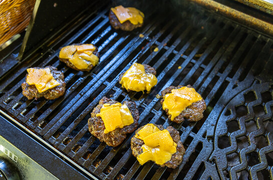 Cheesburger auf einem Gasgrill mit Rindfleisch und K&auml;se &uuml;berbacken