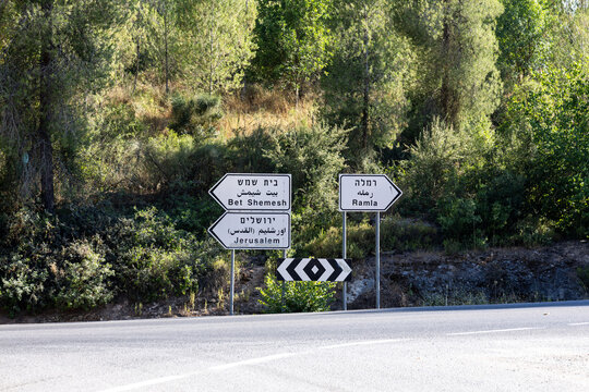 Roadside traffic directional signs pointing toward Jerusalem, Bet Shemesh, and Ramla in Hebrew, Arabic, and English