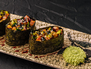 Gunkan maki sushi with eel, cucumber, and wasabi on plate © AntAlexStudio