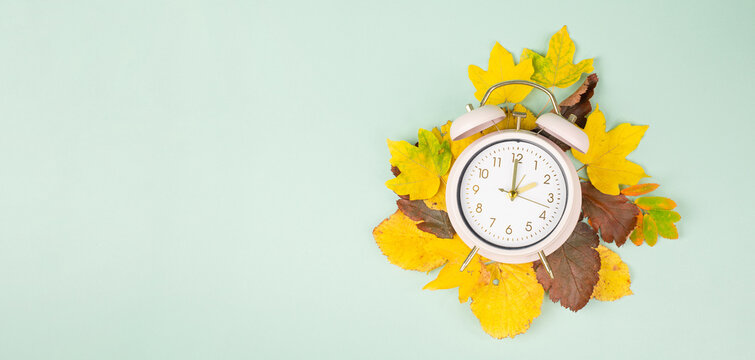 Winter time changeover, end of daylight saving time in autumn, alarm clock fall back switch, colorful foliage