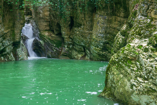 Waterfall and lake in canyon in deep forest