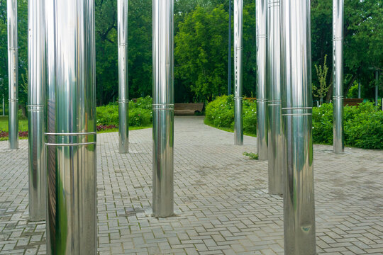 A row of metal pillars in the city park. The photo was taken on a sunny day.