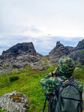 Hiker with backpack and binoculars on the top of the mountain