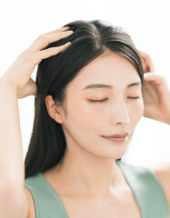 Fototapeta premium 両手でヘッドマッサージをする日本人女性