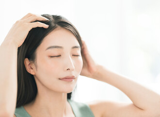 Fototapeta premium 両手でヘッドマッサージをするアジア人女性