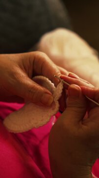 Woman's hands crocheting white yarn piece with hook close up. Handmade crafts, hobbies, slow living, and textile arts concepts.
