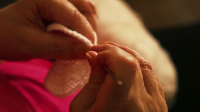 Woman's hands crocheting white yarn piece with hook close up. Handmade crafts, hobbies, slow living, and textile arts concepts.