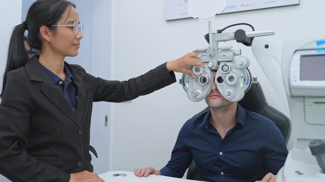 Optometrist conducts eye examination using phoropter to assess vision and prescribe corrective lenses