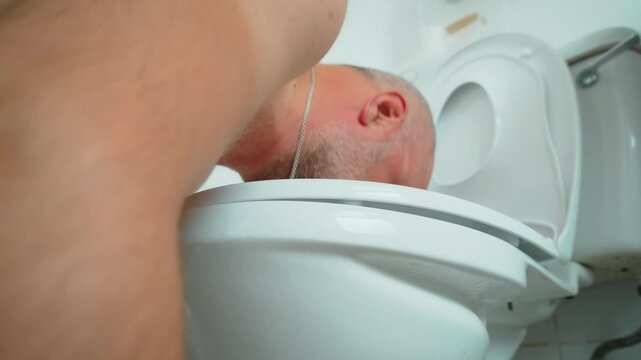 Man vomiting into toilet during severe food poisoning. Adult male experiencing nausea stomach pain and gastrointestinal distress in bathroom. Digestive illness symptoms dehydration risk and sickness