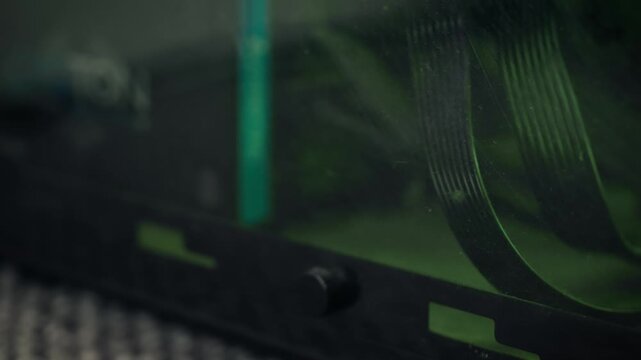 Computer ribbon cables inside dusty case with green ambient lighting. Macro view featuring dirty PC hardware and accumulated dust on internal components. Cyberpunk technology background highlighting