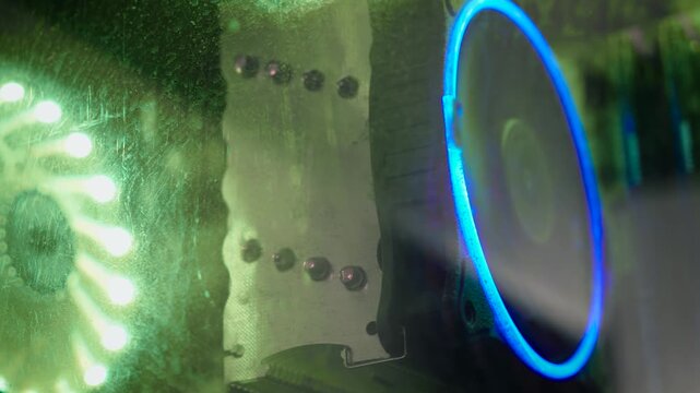 CPU cooler behind dusty computer case glass with RGB lighting. Macro view of gaming PC cooling system covered in dust and fingerprints. Computer maintenance, overheating prevention, and hardware