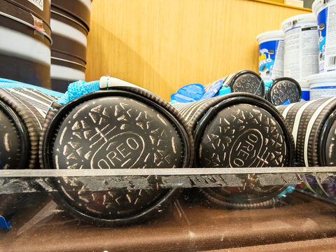 Moscow, Russia - June 22, 2026: Oreo cookie packages stacked on a shelf with blue packaging and containers visible in the background of a grocery store