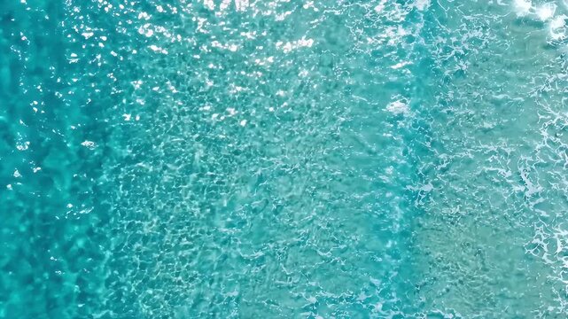 Clear water ocean surface with blue sea sunlight reflection calm tropical water transparent water texture sea wave natural aquatic marine water ripple pattern background ocean water wave sea blue