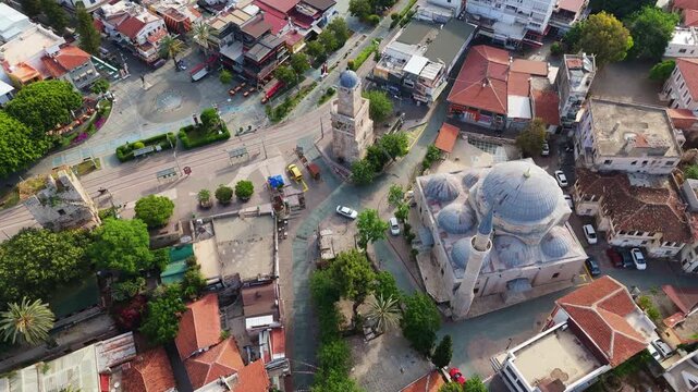 drone tracking shot looking down at an ancient stone mosque dome inside Kaleici district. Detailed urban layout of the historic old town center in Antalya, Turkey