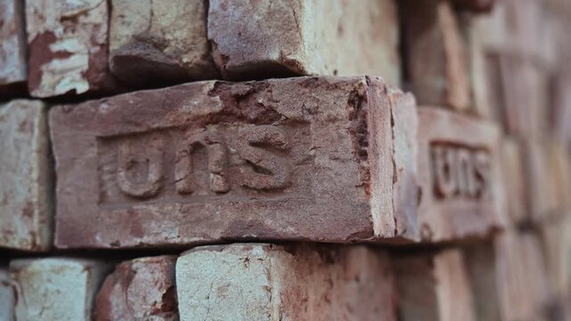 Shallow depth-of-field shot of finished masonry blocks piled at an outdoor brickyard in Bangladesh. Captures traditional industrial production results, infrastructure materials, and local trade.