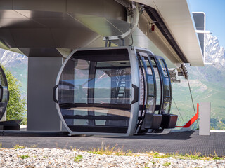 Mountain cable car gondola station, alpine tourism transport, ski resort infrastructure, adventure travel with scenic valley views. © DedMityay