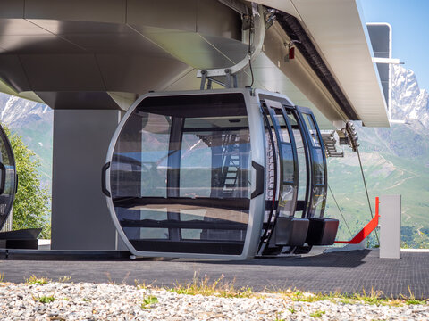 Mountain cable car gondola station, alpine tourism transport, ski resort infrastructure, adventure travel with scenic valley views.