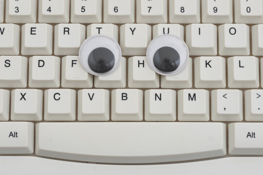 Googly eyes on a white computer keyboard for tracking user activity