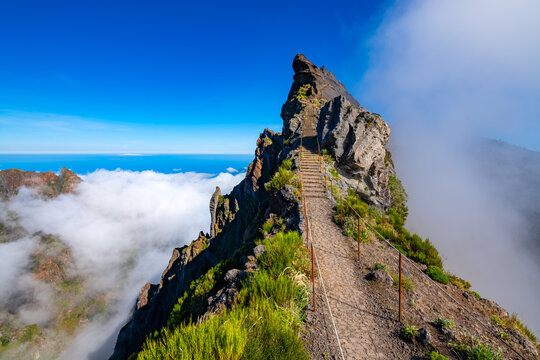 Ninho da Manta &ndash; a scenic trail near the summit of Pico do Arieiro on the island of Madeira, Portugal. A legendary mountain trail with steep cliffs on both sides of the path. Wide angle panorama.
