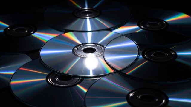 Technology - Multiple Shiny Optical Discs Scattered on Dark Surface with Colorful Rainbow Light Reflections