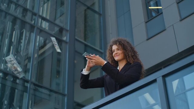 Caucasian business woman throwing cash money rain celebrating financial success in city rich businesswoman investor female girl employer throw dollars in air overspending finance near office building