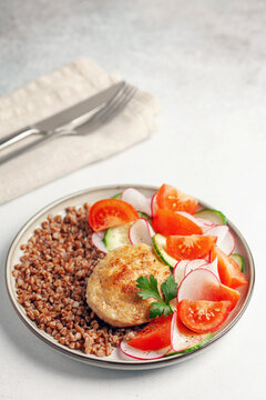 Chicken cutlet with buckwheat porridge and vegetable salad in a plate on the table. Healthy food