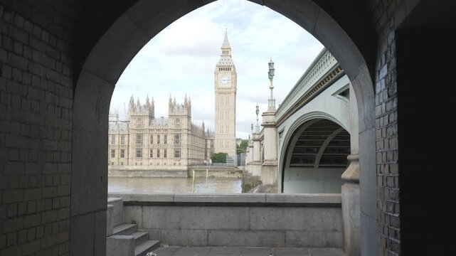 Big Ben and the Houses of Parliament framed by a stone archway.