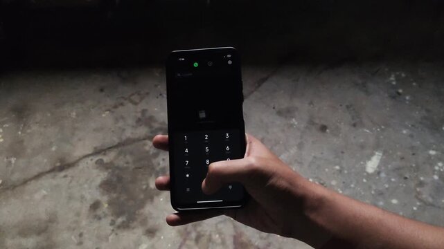 Close Up of Hand Holding Smartphone Running USSD Code Dial MMI Code on Screen