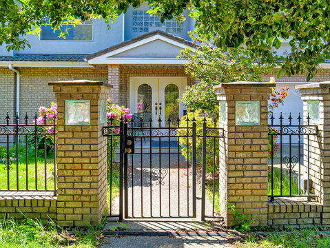 Elegant Brick Pillars and Ornate Wrought Iron Gate