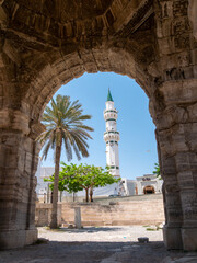 Obraz premium Arch of Marcus Aurelius with the Gurgi Mosque in the background in Tripoli, Libya on a bright afternoon