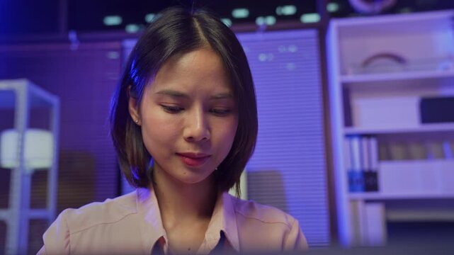 Young Asian businesswoman working on laptop in office, professional corporate employee.