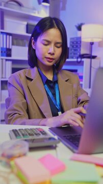 Smiling young Asian woman working on laptop in office, remote work and digital business concept.