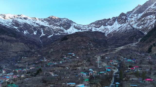 Scenic Aerial View of Sangla Valley Surrounded by Himalayan Mountains with Green Forests, Flowing River, Beautiful Village Landscape, Snow Peaks, Cloudy Sky and Breathtaking Himalayan Nature Scenery