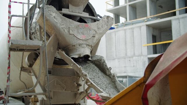Concrete mixer unloading wet concrete at construction site