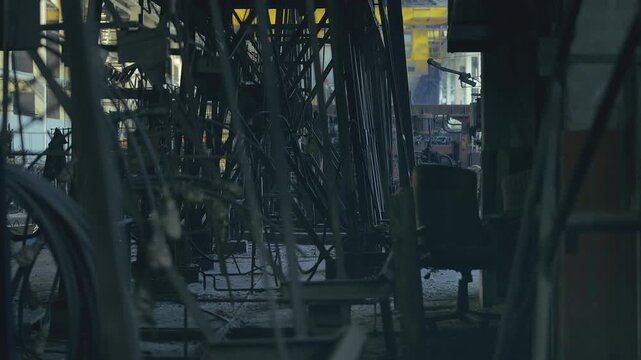 Dark manufacturing plant interior with steel structures and industrial machinery