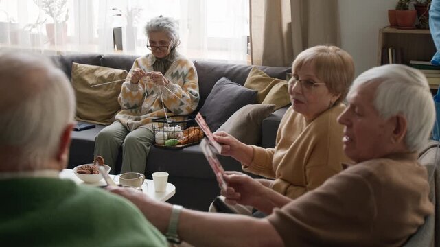 Side view shot of seniors sitting in retirement home looking at old photographs. Clip for promoting assisted living facilities and senior care services