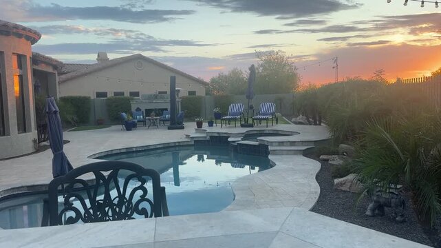 A 4k video clip of a travertine tiled pool deck in Arizona featuring an outdoor fire place, pool, spa and putting green.