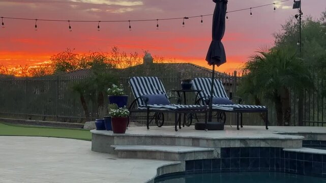 A 4k video clip of a travertine tiled pool deck in Arizona featuring an outdoor fire place, pool, spa and putting green.