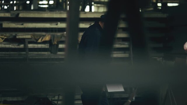 Police officer documenting murder evidence at industrial plant crime scene