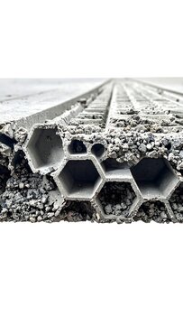 A close-up of a textured surface with hexagonal holes on a gray background