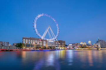 Obraz premium Night view of the Ferris wheel on the Shiqi Riverbank in Zhongshan City, Guangdong Province