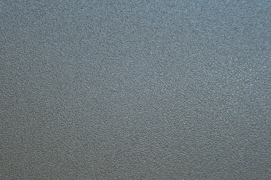 A solid slate-blue background with a subtle, fine-grained texture and a very soft, barely perceptible gradient. The surface offers a clean, matte appearance reminiscent of professional design paper.