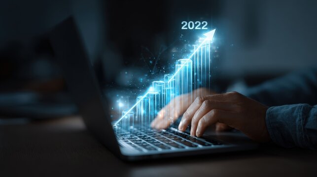 A person typing on a laptop with a glowing blue graph and 2022 arrow on the screen