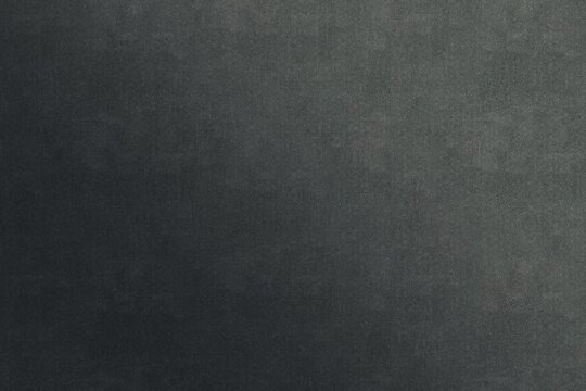 A solid charcoal grey background featuring a subtle, fine-grained texture and a clear, perceptible smooth gradient. The surface mimics the appearance of matte slate, fine cement, or recycled paper.