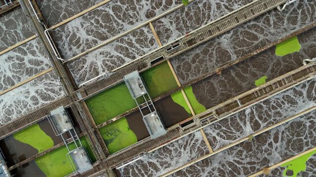 Aerial view of wastewater sewage treatment plant with aeration tanks and bubbling water in Hoddesdon, England, United Kingdom.