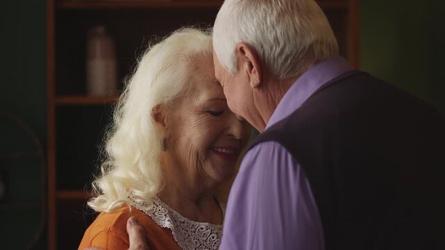 Happy elderly couple leaning foreheads together, expressing love and trust