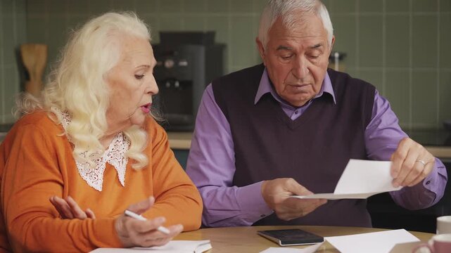 Elderly couple calculating family budget and reading bills, financial hardship